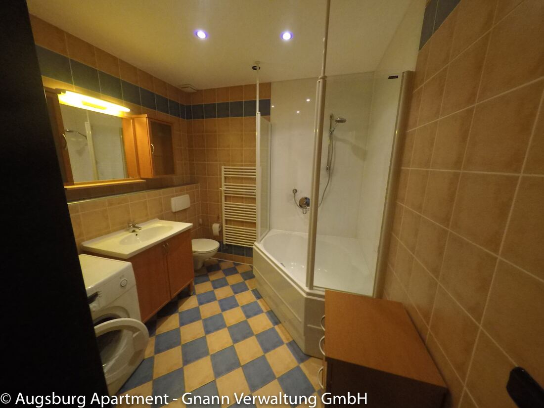 Badezimmer mit Badewanne, Dusche und Waschmaschine in einer möblierten Wohnung in Augsburg