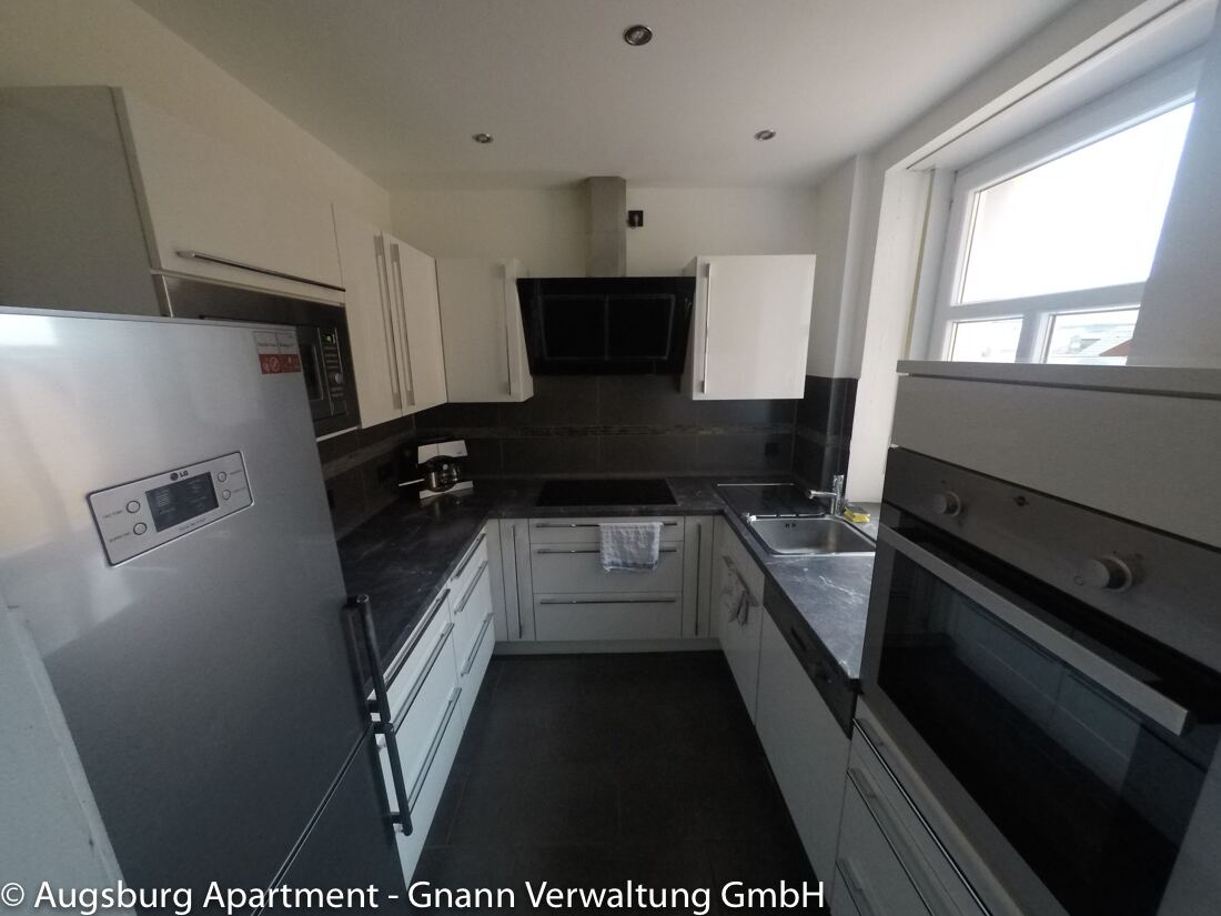 Moderne Einbauküche mit Kühlschrank und Backofen in einer möblierten Wohnung in Augsburg