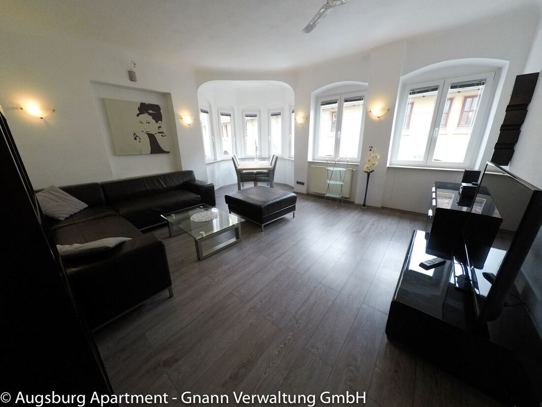 Möbliertes Altbau-Wohnzimmer mit Erker und Sofa-Ecke in der Augsburger Innenstadt